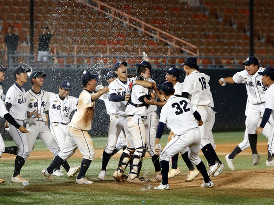 Students from Yushin High School in Suwon, Gyeonggi, celebrate after winning the final of the 77th Blue Dragon Flag National High School Baseball Championship on Monday, beating Seoul's Chungam High School 3-1 at Mokdong Baseball Stadium in western Seoul.  [YONHAP]