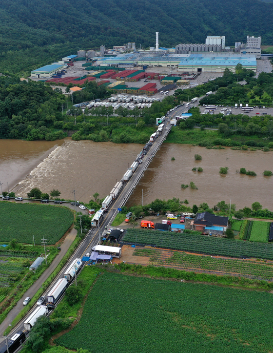 Unionized cargo truck drivers block the entrance of the Hite Jinro factory in Hongcheon County, Gangwon, on Wednesday. This marks the second day of the drivers' protest, disrupting the delivery of Hite Jinro beer from the factory. [YONHAP]