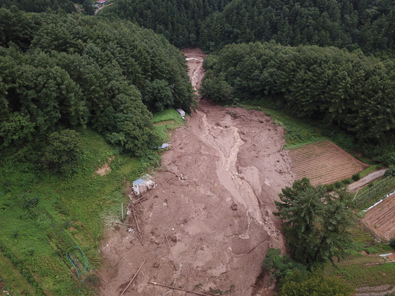Part of a village near the county of Hoengseong is buried under a landslide Wednesday morning. [YONHAP]