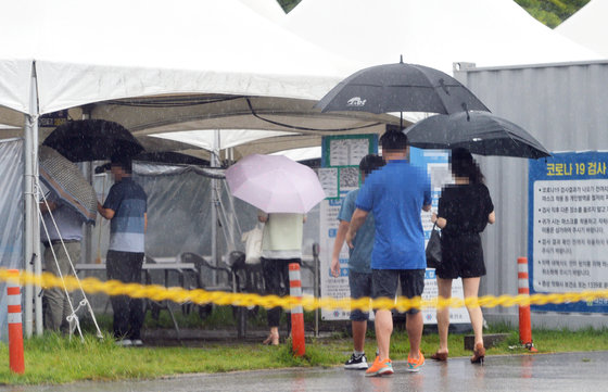 People wait in line to get tested for Covid-19 at a testing center in Daejeon on Thursday. [KIM SUNG-TAE]