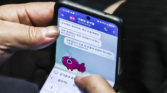 Rep. Kweon Seong-dong, acting chair and floor leader of the People Power Party, responds to a text message from President Yoon Suk-yeol over Telegram during a National Assembly session in Yeouido, western Seoul, Tuesday. [JOINT PRESS CORPS]