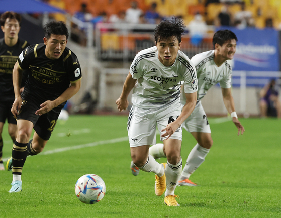 Park su-il of Seongnam FC, center, dribbles the ball past Lee Ki-je of the Suwon Samsung Bluewings on Sunday at Suwon World Cup Stadium in Suwon, Gyeonggi. [YONHAP]