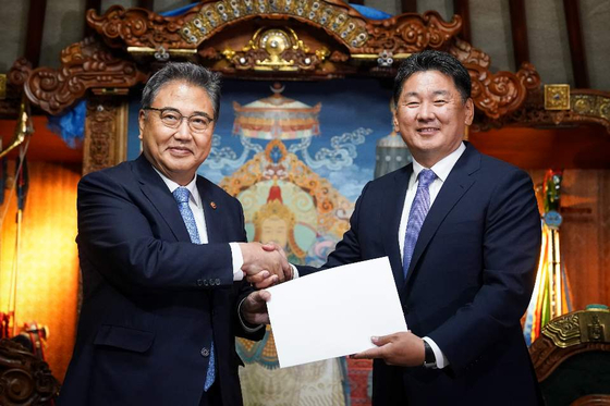 Foreign Minister Park Jin, left, and Mongolian President Ukhnaagiin Khurelsukh shake hands after Park conveyed a letter from President Yoon Suk-yeol in their meeting in Ulaanbaatar on Monday. [MINISTRY OF FOREIGN AFFAIRS]