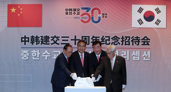 Foreign Minister Park Jin, center left, Chinese Ambassador to Korea Xing Haiming, center right, cut a cake at the official ceremony marking the 30th anniversary of diplomatic relations between Korea and China at the Four Seasons Hotel in central Seoul Wednesday evening. [JOINT PRESS CORPS]