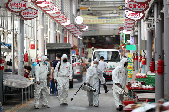 Workers in full protective gear disinfect a traditional outdoor market in Gwangju on Wednesday as Chuseok, or the Korean harvest holiday, approaches. [YONHAP]