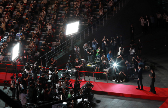 Actors Song Joong-ki, front, and Park So-dam greet the cameras from the red carpet of the opening ceremony of the 26th Busan International Film Festival to host the event on Oct. 6. [YONHAP]  