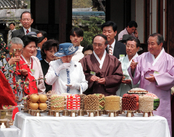 This 1999 file photo shows Queen Elizabeth II, second from left, celebrating her 73rd birthday during her trip to Hahoe Village in the city of Andong, southeastern Korea. [YONHAP]