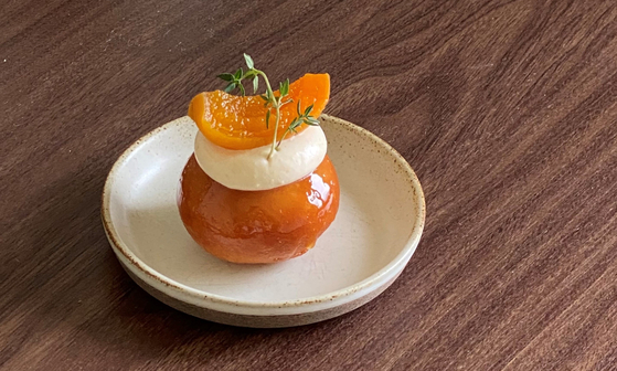 Korean deep-fried rice cake called Kaesong juak topped with a slice of apricot and cream at Yeon Li Hui Jae, a cafe in Paju, Gyeonggi [YEON LI HUI JAE]