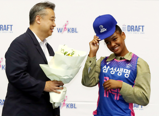 Kiana Smith, right, poses with Yongin Samsung Life Blueminx head coach Im Geun-bae after topping the 2022 WKBL rookie draft at Dowon Gymnasium in Incheon on Friday.  [YONHAP]