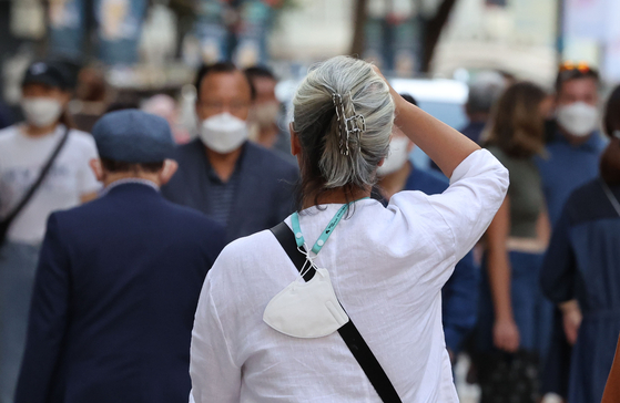A person walks down a street in Myeongdong, central Seoul, without a mask on Tuesday afternoon. [YONHAP]
