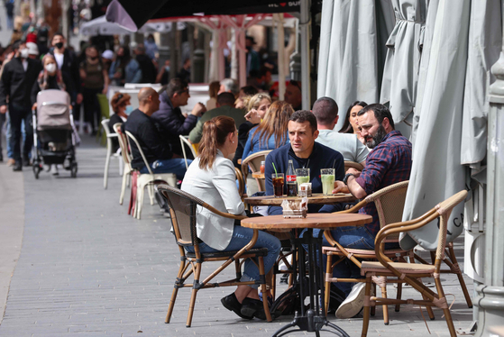 People sit at cafe terraces in Jerusalem on March 9, 2021, after Israeli authorities reopened restaurants, bars and cafes to vaccinated ″green pass″ holders. The pass pollicy was dropped in February this year as Israel saw continued decline in daily cases of infections. [AFP/YONHAP]