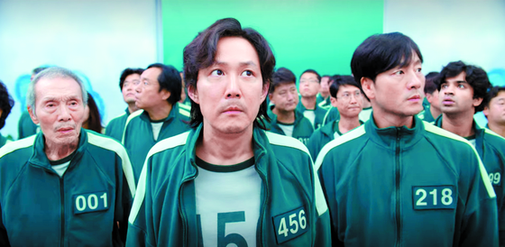 Lee Jung-jae, center, and Park Hae-soo, right, play Gi-hun and Sang-woo in the Netflix series "Squid Game." [NETFLIX]