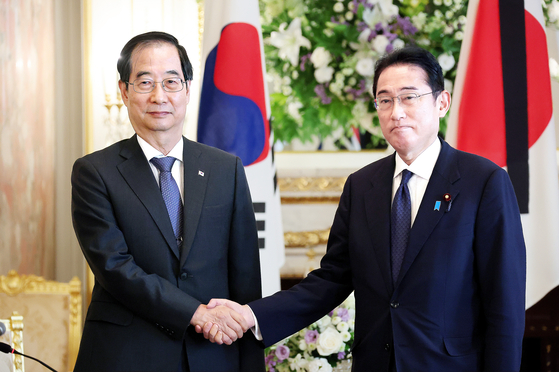 Prime Minister Han Duck-soo, left, shakes hands with Japanese Prime Minister Fumio Kishida during a meeting at the Akasaka Palace, a Japanese state guest house in Tokyo, on Wednesday. [NEWS1] 