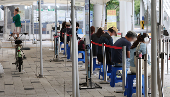 People line up to get tested for Covid-19 at a testing center in Mapo District, western Seoul, on Wednesday. [YONHAP]