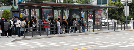 People wait in line at a taxi stand in front of Seoul Station in Seoul on Tuesday. The government introduced measures that would ease the shortage of taxis late at night. [NEWS1] 