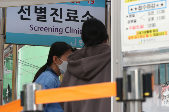 A health worker explains testing guidelines for Covid-19 at a testing center in Jung District, central Seoul, on Thursday. [YONHAP]