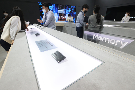 Visitors examine semiconductor chips on display at a Samsung Electronics booth during a semiconductor exhibition held at COEX on Oct. 5. [YONHAP] 