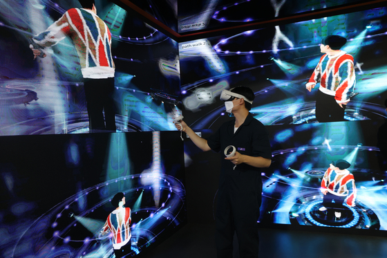 A visitor tries out a virtual reality (VR) device at SK Telecom's booth at the K-Metaverse Festival & Expo 2022 (KMF & KME 2022) held at Coex in Gangnam District, southern Seoul, on Thursday. Hosted by the Ministry of Science and ICT, the event invites 170 companies, such as KT and SK Telecom, to exhibit their digital technologies related to the metaverse industry, including VR and augmented reality (AR) technologies. The event will run through Saturday. [YONHAP]