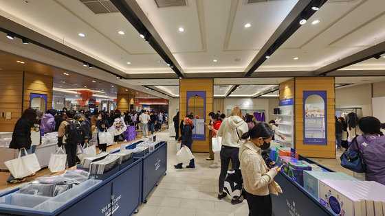 Fans shop at a pop-up BTS merchandise store at Lotte Department Store Busan Branch. [HALEY YANG]
