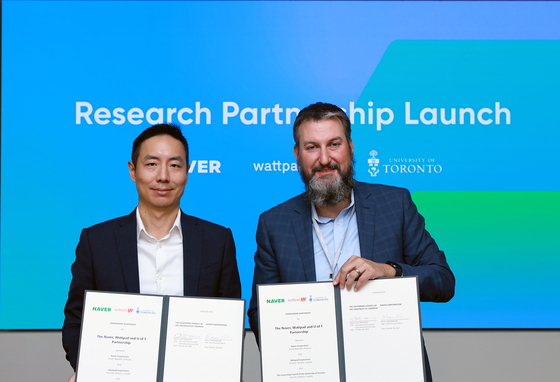 Naver's chief financial officer (CFO) Kim Nam-sun, left, and Alex Mihailidis, Associate Vice-President of International Partnerships in University of Toronto, pose after signing an agreement to develop artificial intelligence technology for Naver's web novel platform Wattpad. [NAVER]