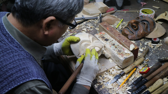 A mask craftsman handcrafts a traditional mask called hahoetal, a type of mask worn in the Hahoe Byeolshingul talchum that dates back to the 12th century. [CULTURAL HERITAGE ADMINISTRATION] 