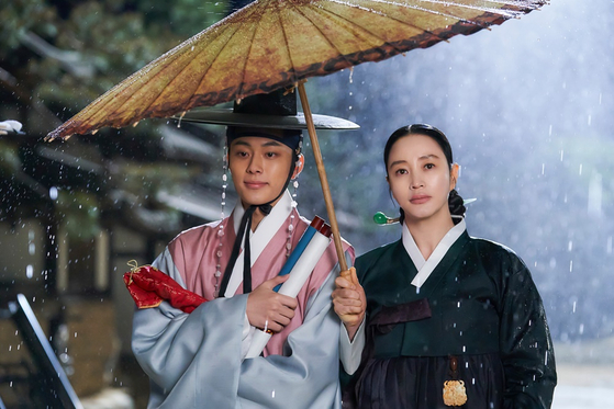 Queen Hwa-ryeong, right, portrayed by Kim Hye-soo, comes to terms with her son’s secret that he likes to put on makeup and dress in women’s clothes in tvN drama series “Under the Queen’s Umbrella.” [TVN]                