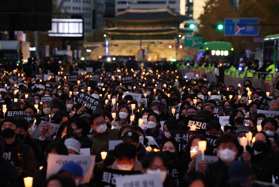 Liberal activists hold a candlelight vigil near City Hall in central Seoul Saturday to commemorate the 156 victims of the Itaewon tragedy on Oct. 29 and demand accountability from the government. Some protesters called for President Yoon Suk-yeol to resign. The national mourning period ended on Saturday, and more than 117,000 people paid respects at mourning altars in Seoul for the victims. President Yoon paid his respects at altars for the victims daily through the mourning period and said he was “profoundly sorry” during a Buddhist memorial service Friday. [YONHAP]