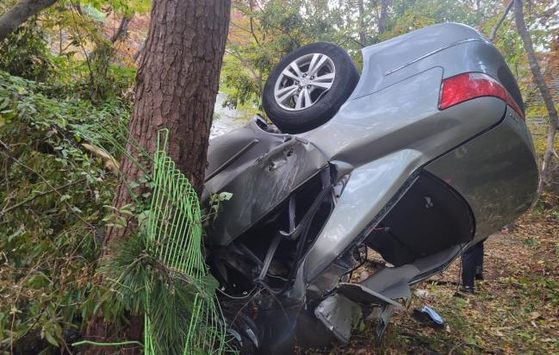 The car in which three people died and two were injured is seen on a slope in Namhae County, South Gyeongsang, on Tuesday. [GYEONGSANGNAM-DO FIRE DEPARTMENT]
