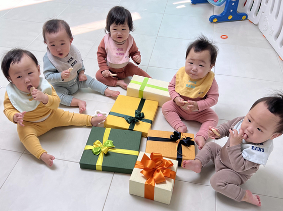The first set of quintuplets born in Korea in 34 years, the Kim siblings, pose for a photo with presents from First Lady Kim Keon-hee on Sunday. [YONHAP]