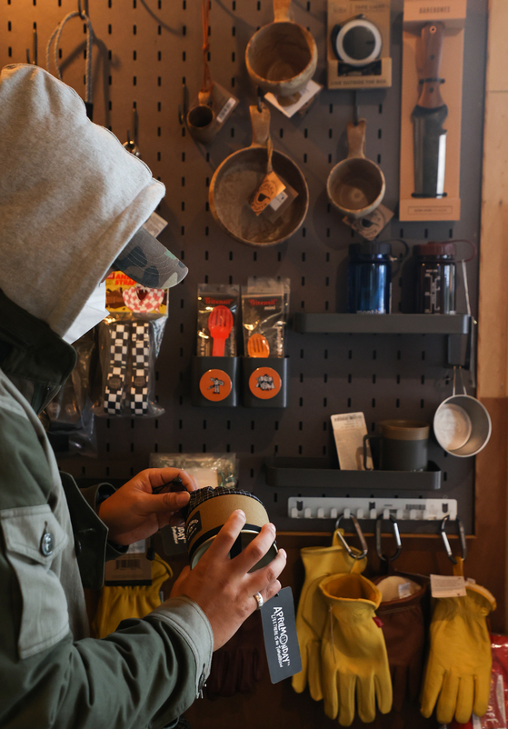 The number of campsites nationwide rose 14.3 percent to 3,205 on year in September, according to the Korea Tourism Association on Tuesday. The increase in popularity is in part due to the Covid-19 pandemic, which saw the country face social distancing measures for months on end. Pictured is a person inspecting camping gear at a specialty store in Seoul, also on Tuesday. [YONHAP]