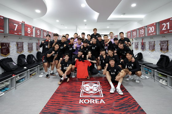 BTS member Jungkook, center, poses with the Korean national football team at the Al Egla Training Facility in Doha, Qatar on Saturday. Jungkook is set to perform at the tournament's opening ceremony on Sunday.  [NEWS1]