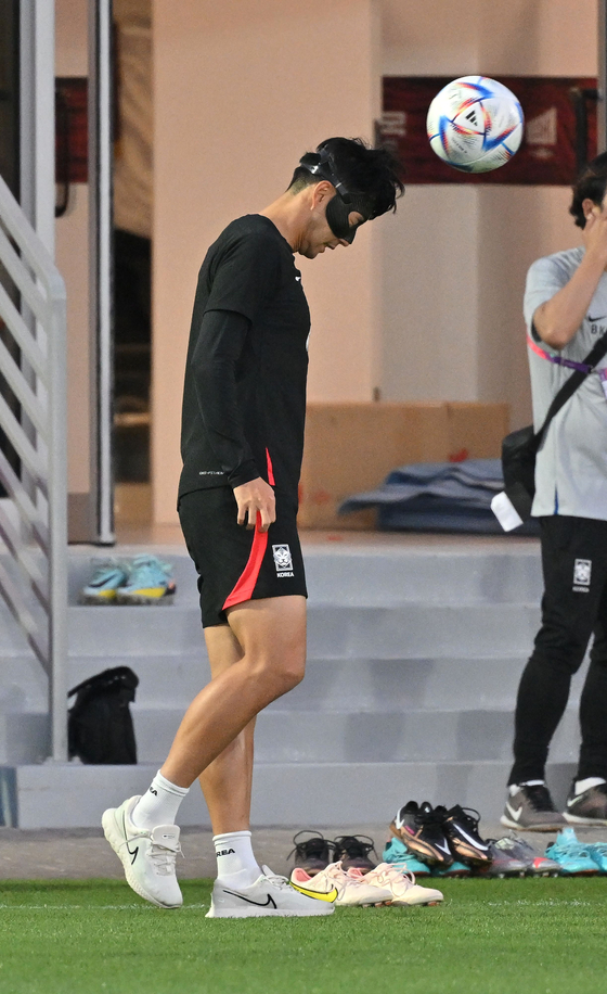 Son Heung-min heads a ball during a training session at Al Egla Training Site 5 in Doha, Qatar on Monday. Monday was the first time that Son was caught on camera heading the ball.  Son’s eye socket was fractured during the 29th minute of a Champions League game between Tottenham Hotspur and Marseille at Stade Velodrome in Marseille, France on Nov. 1. [AFP/YONHAP]