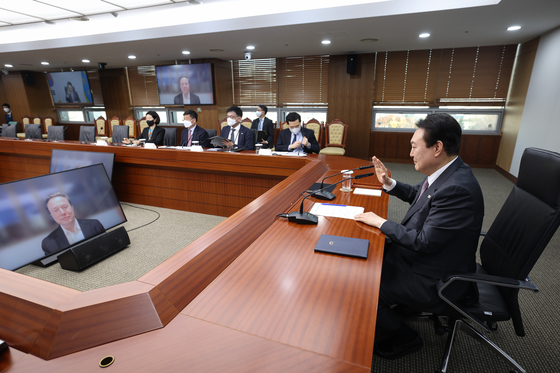 President Yoon Suk-yeol, right, and Elon Musk, on the screen on left, speak during a virtual meeting on Wednesday. [YONHAP]