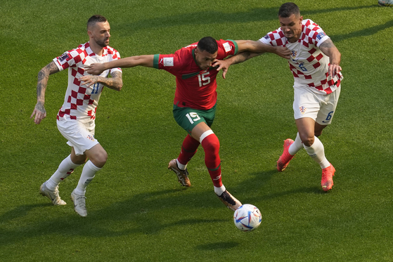 Croatia's Marcelo Brozovic, left, Morocco's Selim Amallah, Croatia's Dejan Lovren, vie for the ball during the World Cup group F soccer match between Morocco and Croatia at the Al Bayt Stadium in Al Khor, Qatar on Wednesday. [AP/YONHAP]