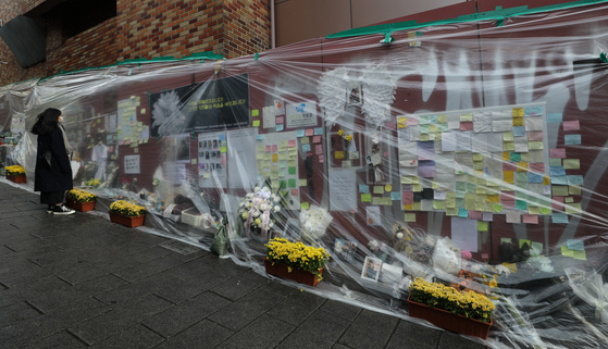 People read messages at a makeshift memorial for the victims of the Oct. 29 crowd crush near Itaewon Station in Yongsan District, central Seoul, nearly one month after the tragedy that claimed 158 lives. [NEWS1]