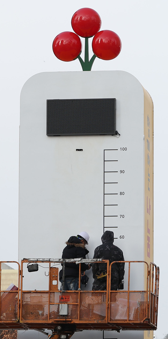 Workers set up the "thermometer of love," which will display the fundraising progress of the Community Chest of Korea's charity campaign, in Gwanghwamun Square in central Seoul, Tuesday. [YONHAP]