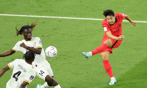 Lee Kang-in, right, shoots during a World Cup Group H match between Korea and Ghana at the Education City Stadium in Al Rayyan, Qatar on Monday. [YONHAP]