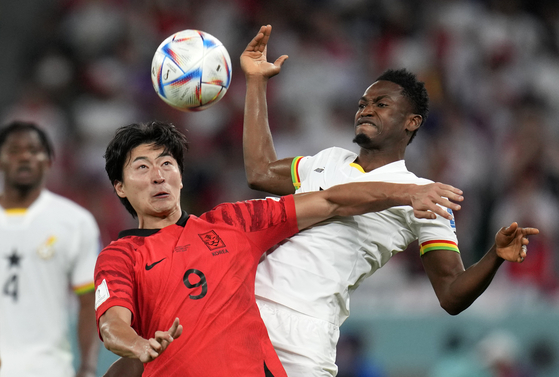 Cho Gue-sung, left, duels for the ball with Ghana's Abdul Rahman Baba during a World Cup Group H match between Korea and Ghana, at Education City Stadium in Al Rayyan, Qatar on Monday. [AP/YONHAP]