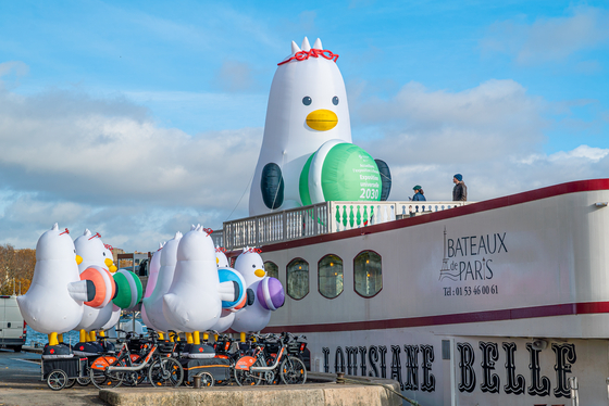 Boogi the seagull, Busan Expo 2030 mascot, sits on a Seine River cruise boat in Paris on Tuesday as the Bureau International des Expositions (BIE) holds its General Assembly in Paris from Nov. 28 to 29. The eight-meter (26-feet)-tall mascot wears glasses, has 'EXPO' glasses on its head and holds a macaroon to promote its bid to host the World Expo. [YONHAP] 