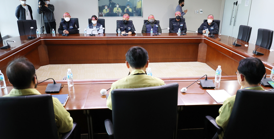 Cargo Truckers Solidarity representative, top, and government officials from the Ministry of Land, Infrastructure and Transport, bottom, sit for negotiations at the Sejong government complex in Sejong on Wednesday. [YONHAP]