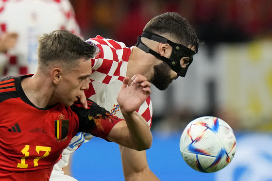 Belgium's Leandro Trossard, left, and Croatia's Josko Gvardiol fight for the ball during the World Cup group F football match between Croatia and Belgium at the Ahmad Bin Ali Stadium in Al Rayyan, Qatar on Thursday. [AP/YONHAP]