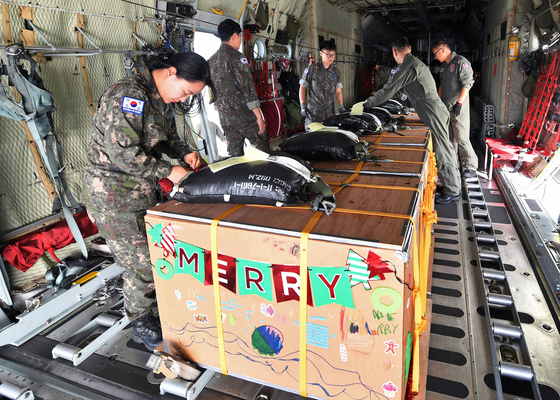 South Korean Air Force personnel secure boxes containing humanitarian supplies to be airdropped to remote islands in Micronesia from a C-130 transport plane on Sunday as a part of the weeklong U.S.-led Operation Christmas Drop. [AIR FORCE]