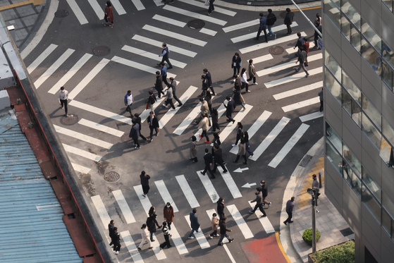 Office workers cross a street in a commercial neighborhood of Jongno District, central Seoul, on Nov. 1, 2022. [YONHAP]