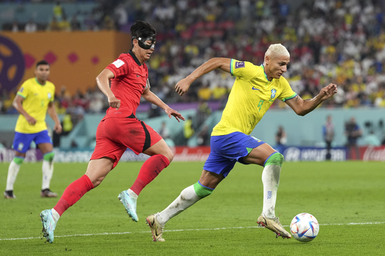 Richarlison, right, vies with Son Heung-min during a round of 16 match at the 2022 FIFA World Cup at Stadium 974 in Doha, Qatar on Monday. [XINHUA/YONHAP]