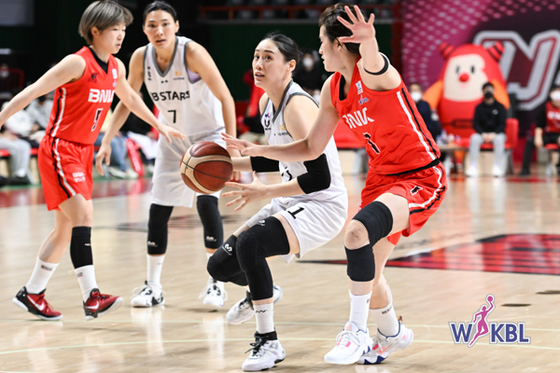 Kang Lee-seul of the Cheongju KB Stars, center, plays the ball during a match against Busan BNK Sum on Monday at Sajik Indoor Gymnasium in Busan. The KB Stars eventually lost 69-60, extending their losing streak to seven matches. The defending champions have been struggling since the start of the season as they are playing without star player and reigning WKBL MVP Park Ji-su.  [WKBL]