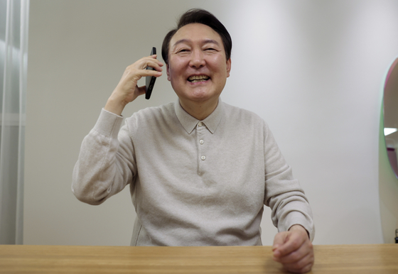 President Yoon Suk-yeol speaks on the phone with members of Korea's national football team from the presidential residence in central Seoul Saturday. [PRESIDENTIAL OFFICE]