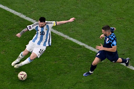 Argentina's forward Lionel Messi vies with Croatia's midfielder Mateo Kovacic during the Qatar 2022 World Cup semi-final match between Argentina and Croatia at Lusail Stadium in Lusail, north of Doha, on Tuesday. [AFP/YONHAP]