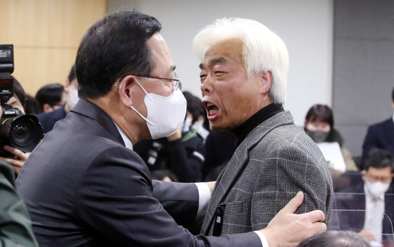 People Power Party (PPP) floor leader Joo Ho-young, left, tries to comfort Lee Jong-cheol, head of an association of families of victims of the Itaewon disaster, at the National Assembly in Yeouido, western Seoul, on Tuesday. [JOINT PRESS CORPS]