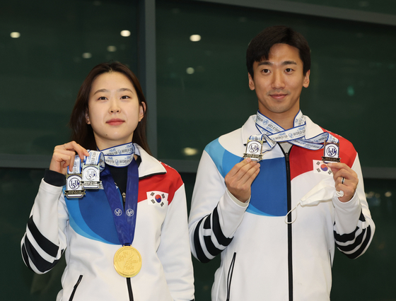 Korean speed skaters Kim Min-sun, left, and Kim Jun-ho hold up their medals while posing for a picture at the Incheon International Airport on Tuesday. The pair won the women's and men's 500-meter gold medals at the Calgary ISU Speed Skating World Cup in Calgary, Canada over the week. Kim Min-sun has won four World Cup gold medals this season, one World Cup silver medal and two Four Continents Championship gold medals, while Kim Jun-ho has won one World Cup gold medal, two World Cup bronze medals and one Four Continents Championship bronze medal. [YONHAP]
