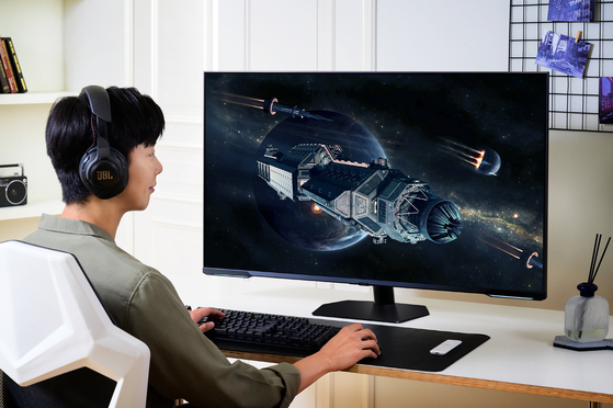 A model takes a photo with Samsung Electronics' latest 43-inch Odyssey Neo G7 gaming monitor [SAMSUNG ELECTRONICS]